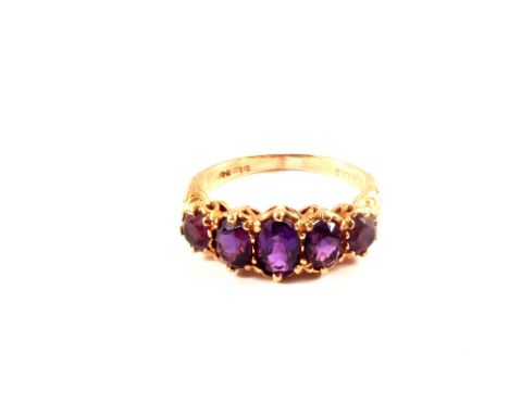 A 9ct gold five stone amethyst ring with ornate shoulders, size K