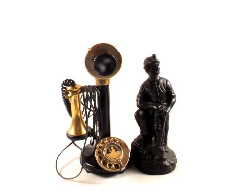 A reproduction brass and Bakelite stick telephone plus a figure of a miner