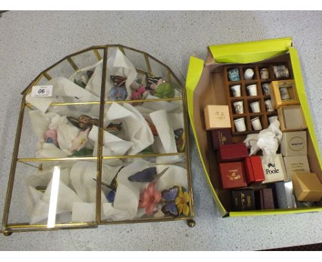 A display case of decorative ceramic butterflies plus various thimbles