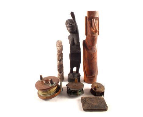 Three tribal wooden figures, three vintage fishing reels plus a tin of flies