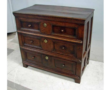 An early 18th century joined oak Chest of Drawers, the thin boarded three plank top above three indented geometric moulded dr