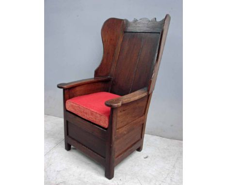 A late 18th/early 19th century oak wingback Lambing style Armchair, shaped top rail over plain two plank panel, shaped outswe