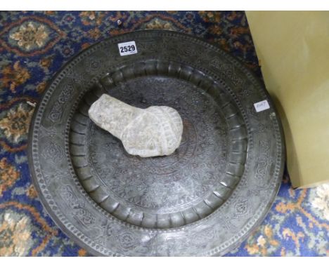 AN EASTERN SILVERED COPPER DISH AND AN ARCHAIC STYLE CARVED STONE FRAGMENT OF A PORTRAIT BUST.