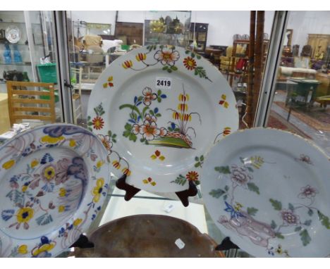 A DELFTWARE POTTERY PLATE, THE CENTRE WITH TERRACE SCENE, 30CM DIAMETER TOGETHER WITH TWO SIMILAR PLATES, 22CM DIAMETER (3)
