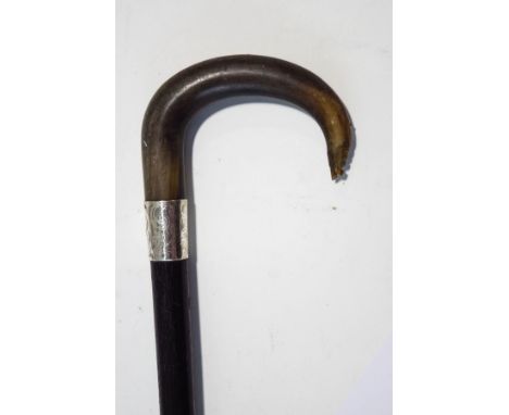 An ebonised walking stick with horn handle and silver band, London 