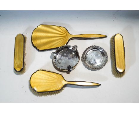 A silver and yellow enamel mounted dressing table set, Birmingham 1913, a silver pin tray, Birmingham 1898 and a silver ash t