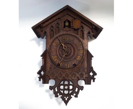 An early 20th century Black Forest cuckoo clock, with eight day movement, Gothic style carving to the case and pendulum mount