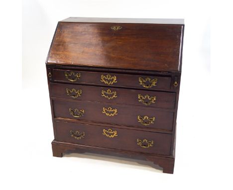 A George III mahogany bureau, the fall front enclosing a pigeon hole interior and drawers, over four long drawers and bracket