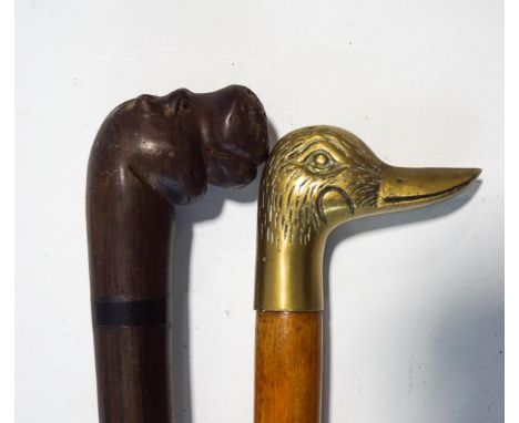 A carved hardwood walking stick, modelled with a hippo's head, and a further walking stick, the handle modelled as a brass du