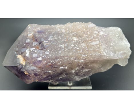 A large Brazilian raw amethyst point with stand. Small natural orange/brown inclusions throughout. Approx. 24 x 11cm at large