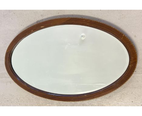 A vintage oval wooden framed bevel edged mirror with inlay detail to frame. Approx. 73 x 42.5cm. 
