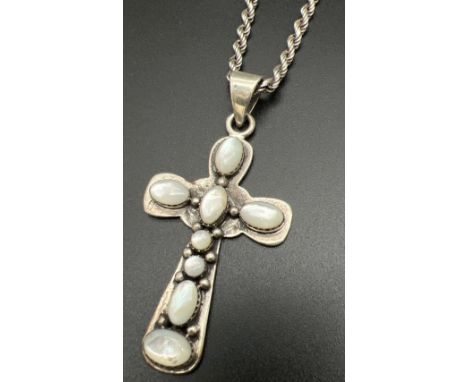 An Arts &amp; Crafts style large silver cross shaped pendant on an 18" silver twisted rope chain. Pendant set with oval and r