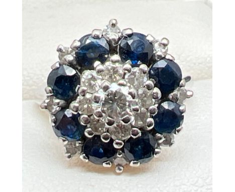 A vintage white gold diamond and sapphire cluster ring. Set with 17 round cut diamonds in varying sizes and 8 round cut sapph