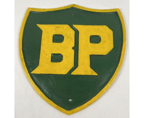 A large cast iron shield shaped BP wall plaque, painted green &amp; yellow. With holes for fixing. Approx. 34cm x 33cm. 