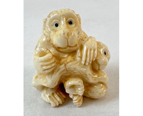 A carved netsuke models as monkeys, with signature mark to underside, possibly bone. Approx. 4cm tall. 