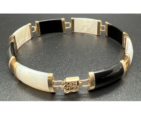 A 9ct gold 8 panel onyx and mother of pearl bracelet with push clasp and safety clip. Chinese character detail to clasp with 