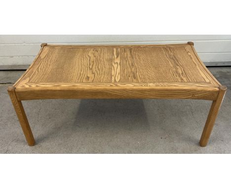 A mid century light wood coffee table with curved edges and square shaped legs. Approx. 41cm tall x 107cm long.