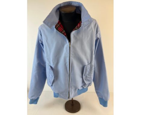 A men's classic Harrington jacket in light blue, in as new condition. With red tartan lining, buttoned slit pockets and elast