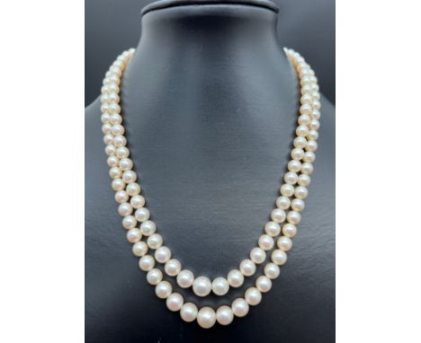 A vintage cream cultured pearl double row necklace with 14ct white gold clasp set with pearls and rubies. Floral design push 