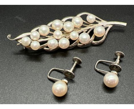 A vintage white metal and cultured pearl leaf shaped brooch with a pair of white metal single pearl screw back earrings. Both