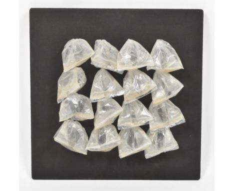 16 plastic sandwich bags filled with water (now evaporated), mounted on black flannel on chipboard, 50 x 50 x 4 cm. The backs