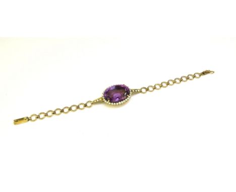 A bracelet centrally set with an oval amethyst framed by clear stones, unmarked, 16.5cm long 