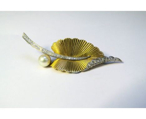 An 18ct gold and platinum brooch as a stylised leaf, the textured gold leaf with a platinum set diamond upturned edge and ste