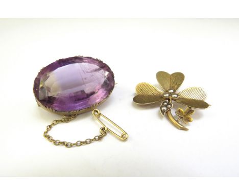 An unmarked gold shamrock leaf form brooch with seed pearl decoration, 3.4g and an oval amethyst brooch 