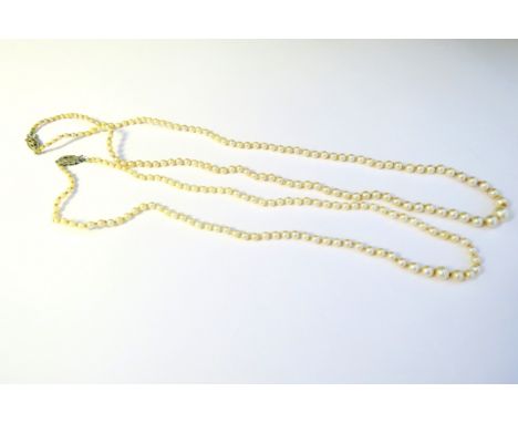 Two single strand pearl necklaces each with a diamond set clasp 