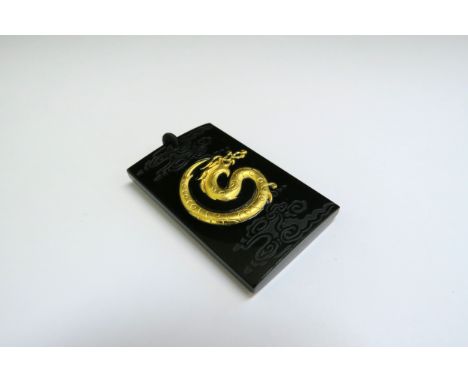 A black jade pendant of rectangular form, inset with 999.9 gold dragon, 4.5cm x 2.8cm 