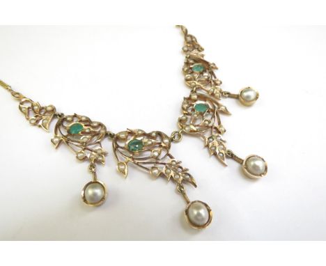 An emerald and seed pearl studded necklet the central four panels hung with a pearl droplet, on later metal chain, 39cm long,