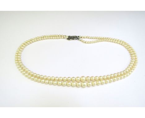 A double strand cultured pearl necklace, circa 1930, clasp stamped 9ct, 46cm long, boxed 