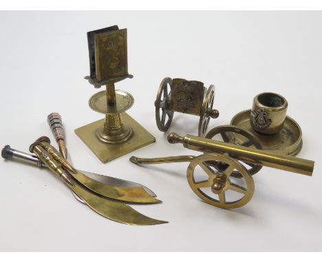 Trench Art collection including 4x paper knives, gun carriage with Hawke bn badge, cannon, a Ubique match stand, and a light 