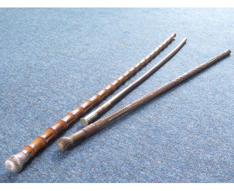 Walking sticks inc a German carved WW2 era stick, R.W.F. long swagger stick and a silver toped cane hallmarked 1883 (3)