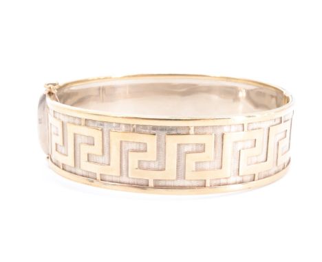A 9 ct yellow metal gold hinged cuff bangle, shallow relief decorated in a Greek key pattern, 6 cm x 5.5 cm internally, 18 mm