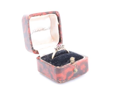 An early 20th Century ruby and diamond ring, having a central 0.4 carat ruby set between two diamonds (0.2 carat aggregate we