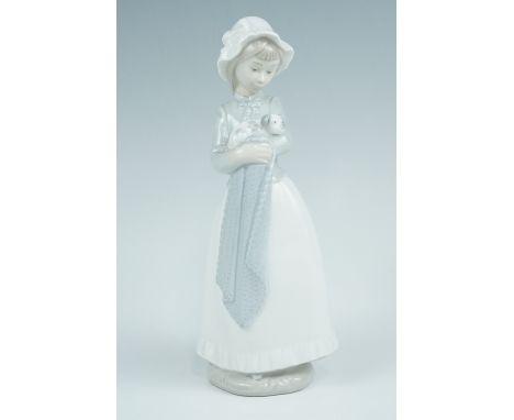 A late 20th Century NAO porcelain figurine of a young girl holding a puppy in her arms, 25 cm