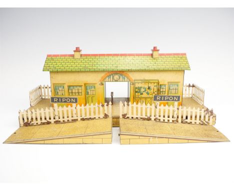 A 1930s Hornby O-gauge model railway tinplate station, together with two platform ramps, station 42.5 x 18 x 15 cm