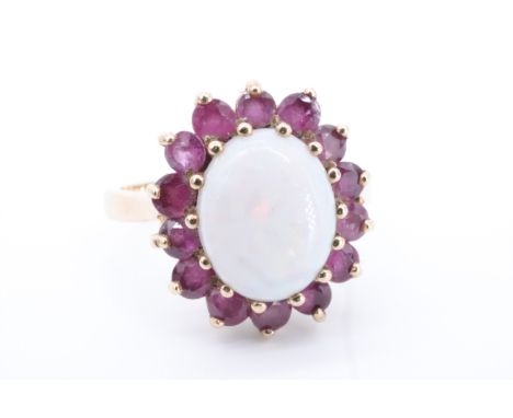 An opal and ruby dress ring, comprising an oval opal cabochon of approx 10 mm x 8 mm framed by claw-set rubies on 9 ct gold, 