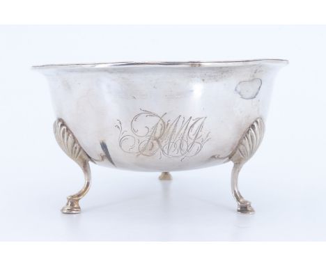 A George III silver sugar basin, raised on short cabriole legs with shell-form hips, bearing an engraved monogram and armoria