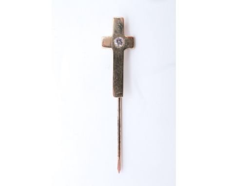 A modern yellow metal and garnet tie stick pin in the form of a cross, having a small white stone flush set in the intersecti