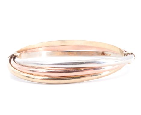 A 9 ct three colour triple-hoop bangle, 6 cm x 5.5 cm internally, 11.4 g