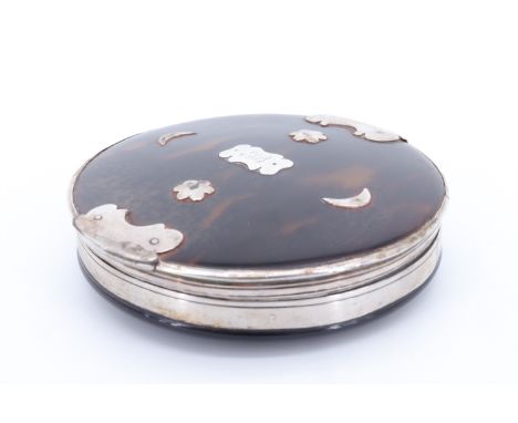 An 18th Century white metal mounted tortoiseshell pocket snuff box, of discuss form, the hinged lid decorated with applied fl
