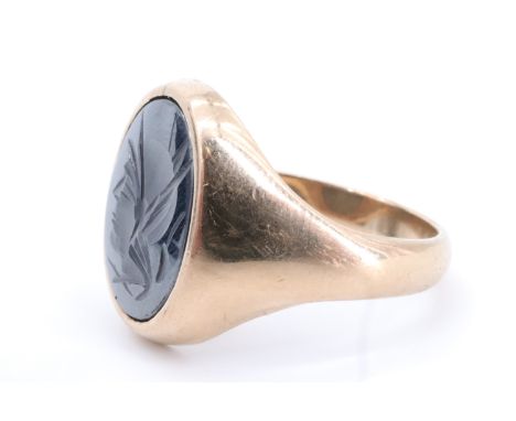 A 9 ct gold signet ring having an oval haematite matrix intaglio carved in depiction of the profile bust of a classical Graec