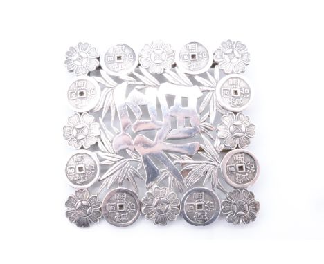 An early 20th Century Chinese white metal brooch formed from half a belt buckle, decorated with pierced and engraved decorati