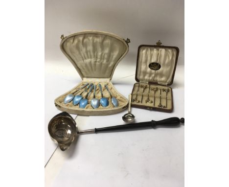 A cased set of silver and enamel tea spoons together with a Georgian silver toddy ladle a silver caddy spoon and a cased set 