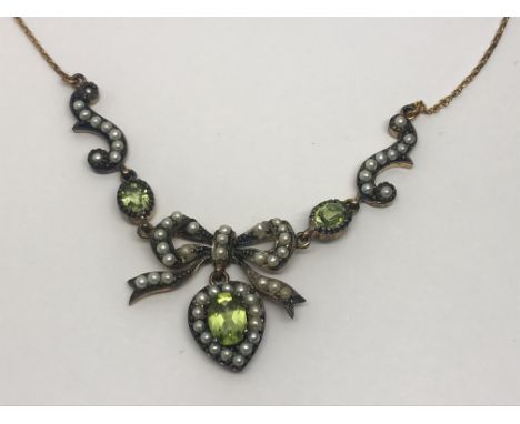A boxed peridot and pearl pendant suspended on a 9ct gold chain, approx 6.4g.