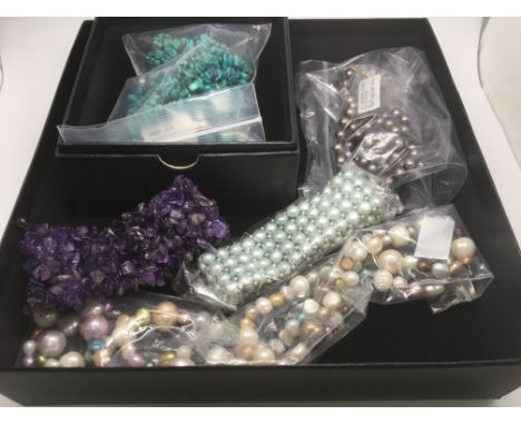 A box containing a pearl bracelet, necklaces and other jewellery.