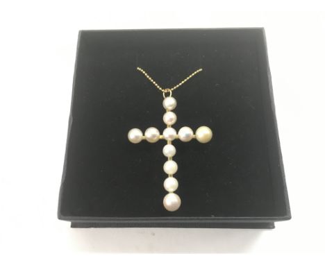 A cultured pearl cross on chain.
