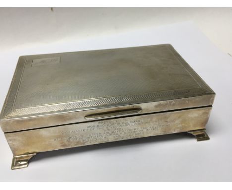 A silver desk top cigarette box of rectangular shape with engine turned decoration and personal inscription. Cedar wood lined